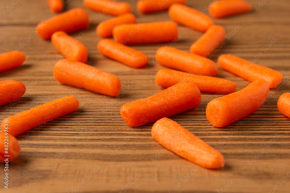 Small peeled pieces of carrot on textured wooden table Small peeled pieces of carrot on textured wooden table