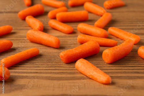 Small peeled pieces of carrot on textured wooden table photo