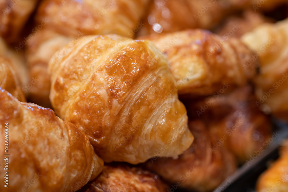 Fresh butter croissants with chocolate sprinkles for sale at bakery store