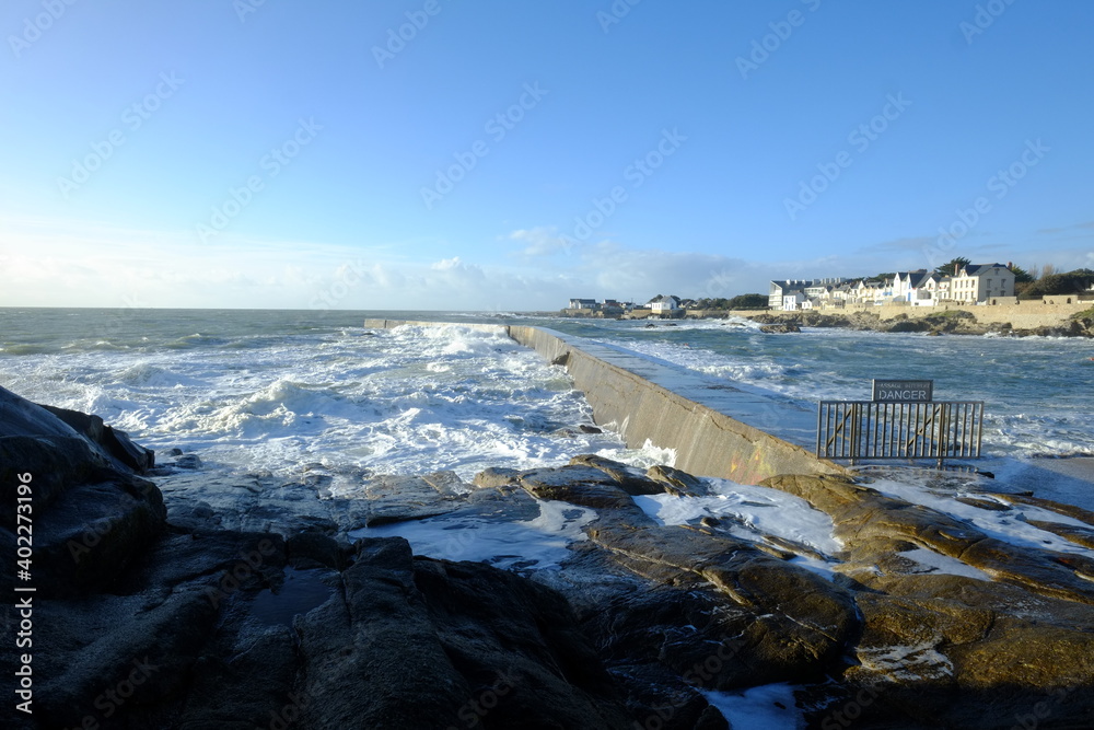 A wave hitting a pier at Batz-sur mer. West of France - december 2020