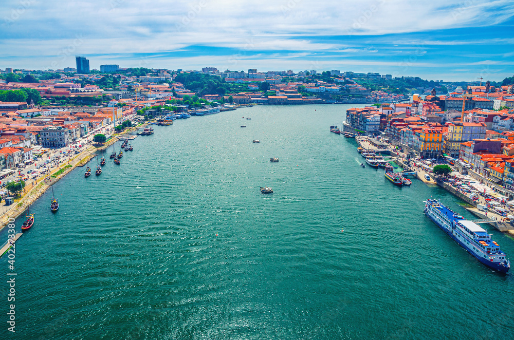 Aerial panoramic view of Porto Oporto city historical centre with Douro River with boats between Ribeira district and Vila Nova de Gaia town, Norte or Northern Portugal