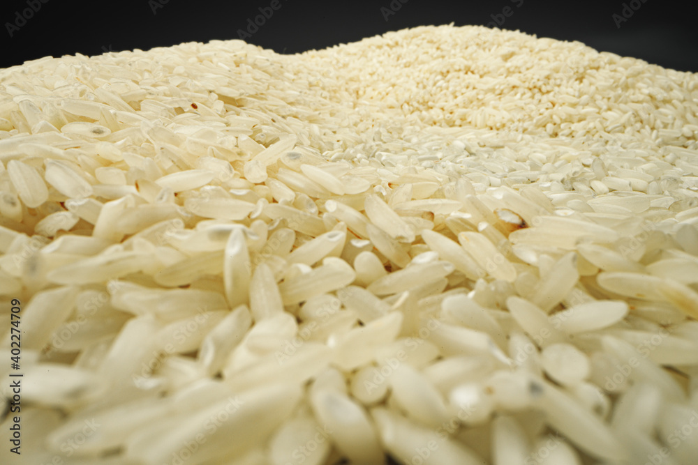 Uncooked dry rice grain on dark background macro Uncooked dry rice grain on dark background macro
