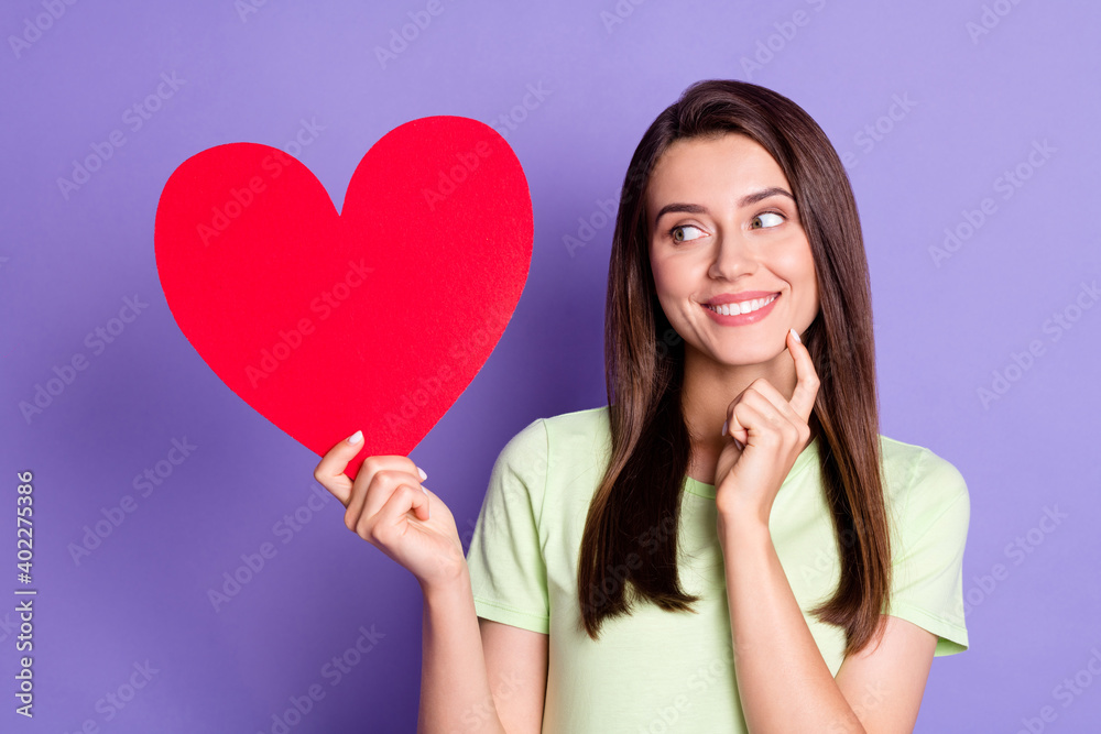 Photo portrait of cheerful girl showing looking at heart on valentines day touching face isolated on bright violet color background Photo portrait of cheerful girl showing looking at heart on valentines day touching face isolated on bright violet color background