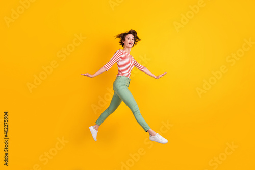 Fototapeta Naklejka Na Ścianę i Meble -  Full length body size profile side view of lovely cheery girl jumping going isolated over bright yellow color background