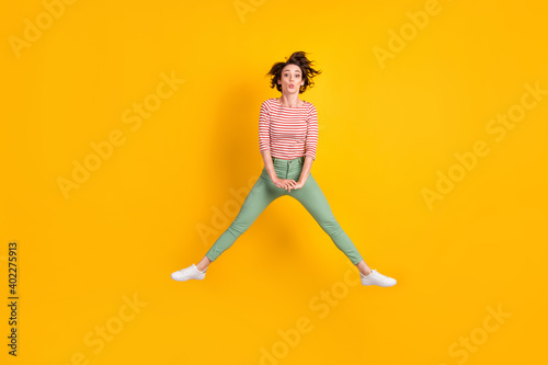 Full length body size view of lovely skinny funky girl jumping having fun sending air kiss isolated over vivid yellow color background