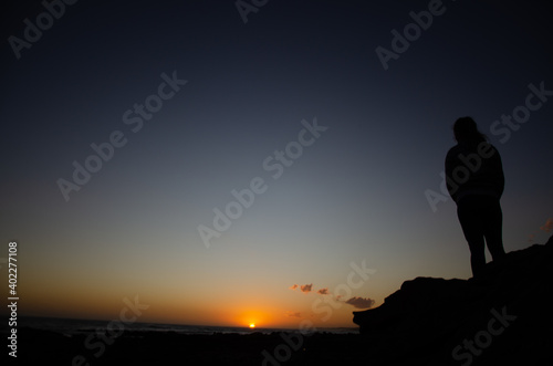 silhouette of a person standing on a rock