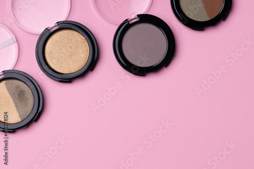 Set of eyeshadows make up products on pink