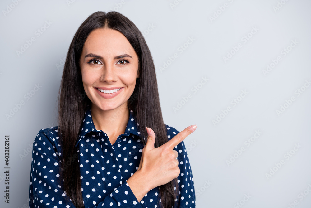 Portrait of attractive cheery long-haired lady demonstrating copy empty blank space place isolated over grey pastel color background