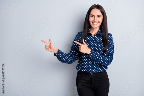 Portrait of lovely cheery content long-haired lady showing idea copy space isolated over grey pastel color background