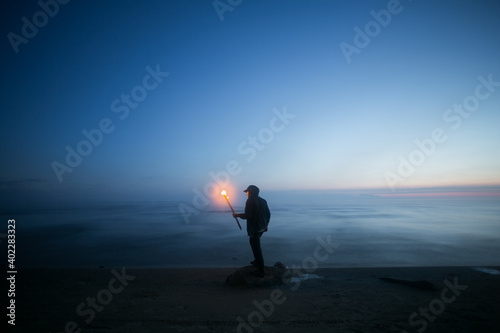 Man with fire on the river.