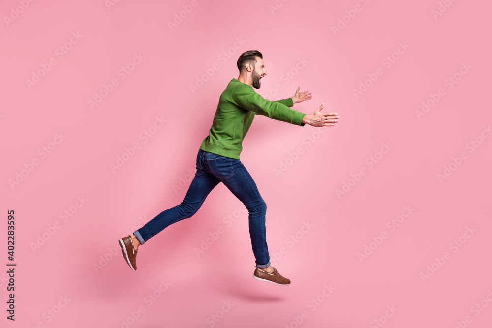 Full length body size profile side view of nice cheerful guy jumping running hugging copy space isolated over pink pastel color background