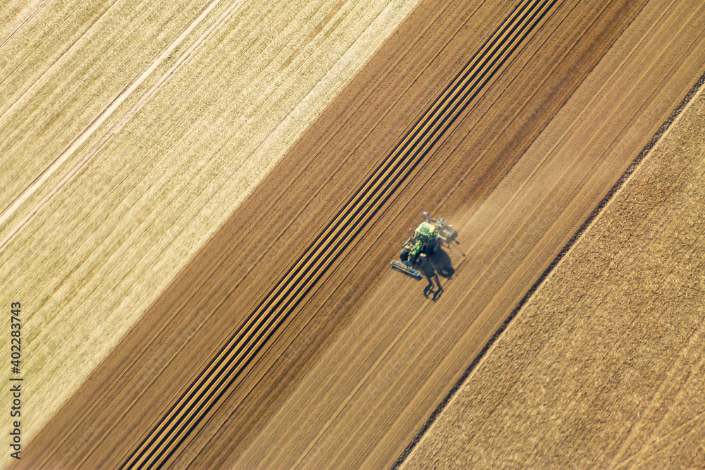 Traktor pflügt ein Feld, Luftaufnahme Traktor pflügt ein Feld, Luftaufnahme