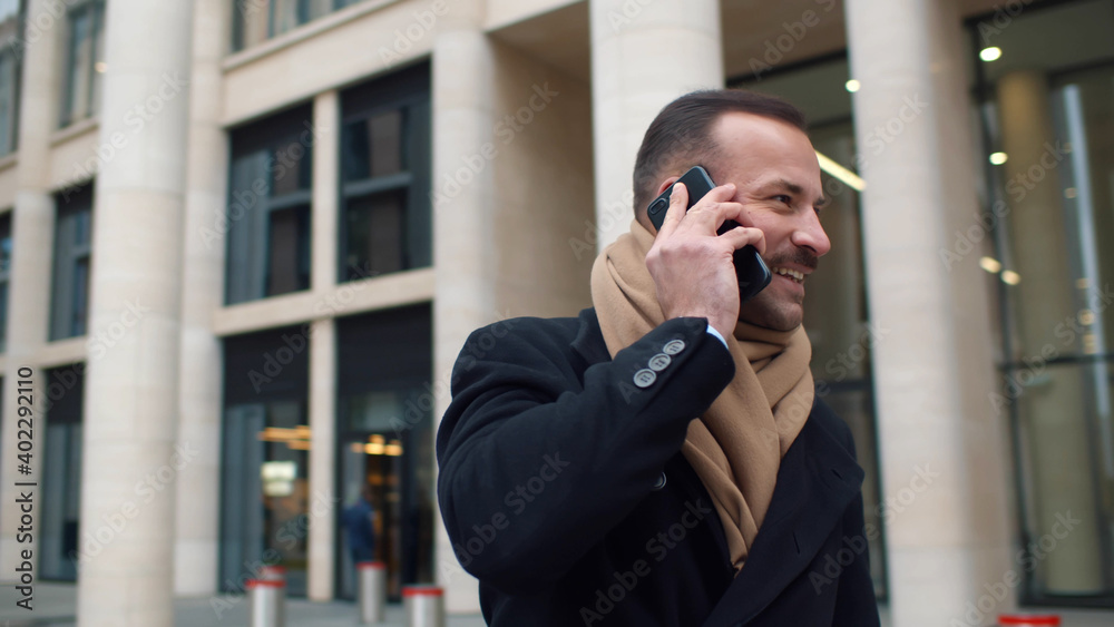 Handsome young businessman dressed in formal clothes having phone call standing outdoors Handsome young businessman dressed in formal clothes having phone call standing outdoors