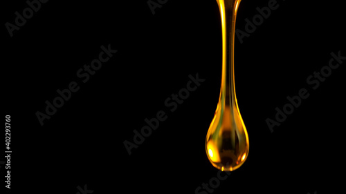 Pouring oil drop isolated on black background. Macro shot.
