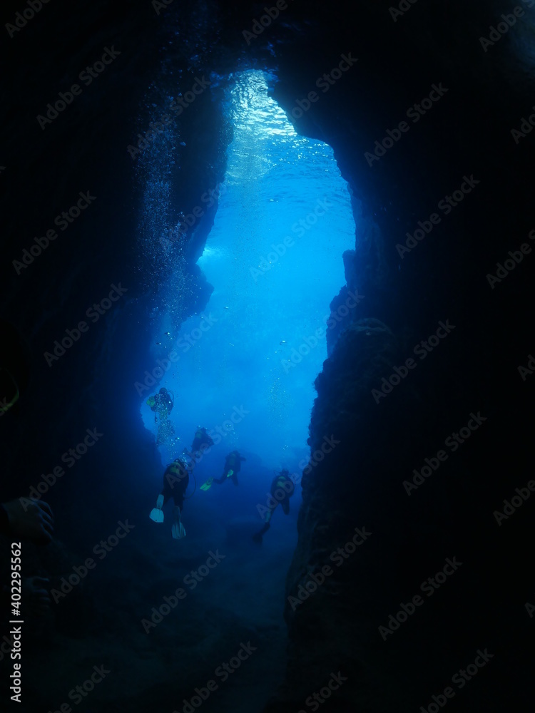 Fototapeta premium cave diving underwater scuba divers exploring caves and having fun ocean scenery sun beams and rays background