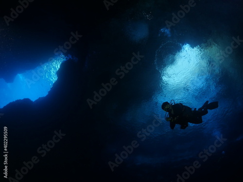 cave diving underwater scuba divers exploring caves and having fun ocean scenery sun beams and rays background