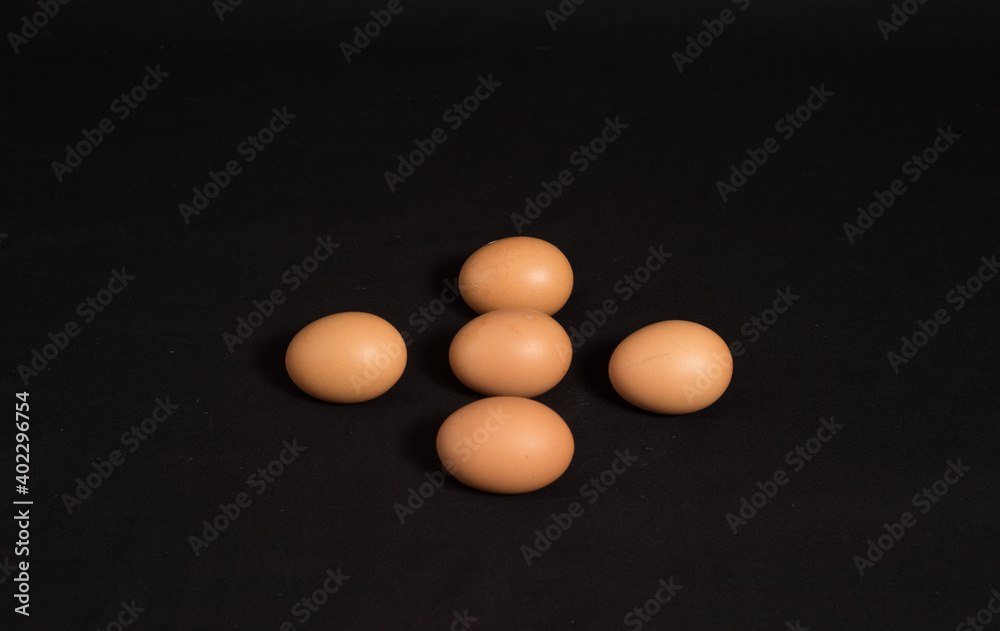 High angle shot and top view of five eggs isolated on black background. High angle shot and top view of five eggs isolated on black background.