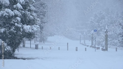 Snow falling in Bled, Slovenia. Famous promenade covered with snow. Snowstorm in winter season. Static shot, wide angle