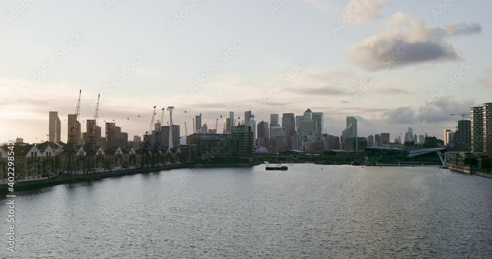 Canary Wharf and City of London, United Kingdom. Financial district captured from Royal Victoria Dock during sunset. Panning across East London skyline Canary Wharf and City of London, United Kingdom. Financial district captured from Royal Victoria Dock during sunset. Panning across East London skyline