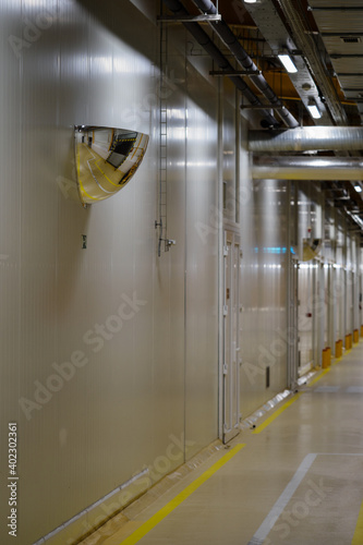 Safety convex mirror in an industrial corridor.