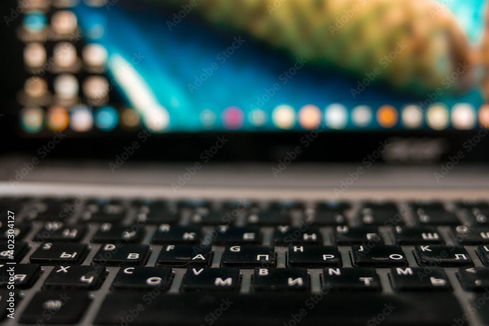 Laptop keyboard. The display is blurred. Bright laptop. White letters and black keys. Gray computer. Digital technologies. Laptop keyboard. The display is blurred. Bright laptop. White letters and black keys. Gray computer. Digital technologies.