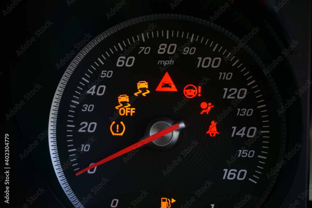 Close up of speedometer dial with warning lights on a car