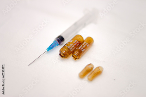 Empty medical ampoules infusion and used syringe after injection isolated on white background