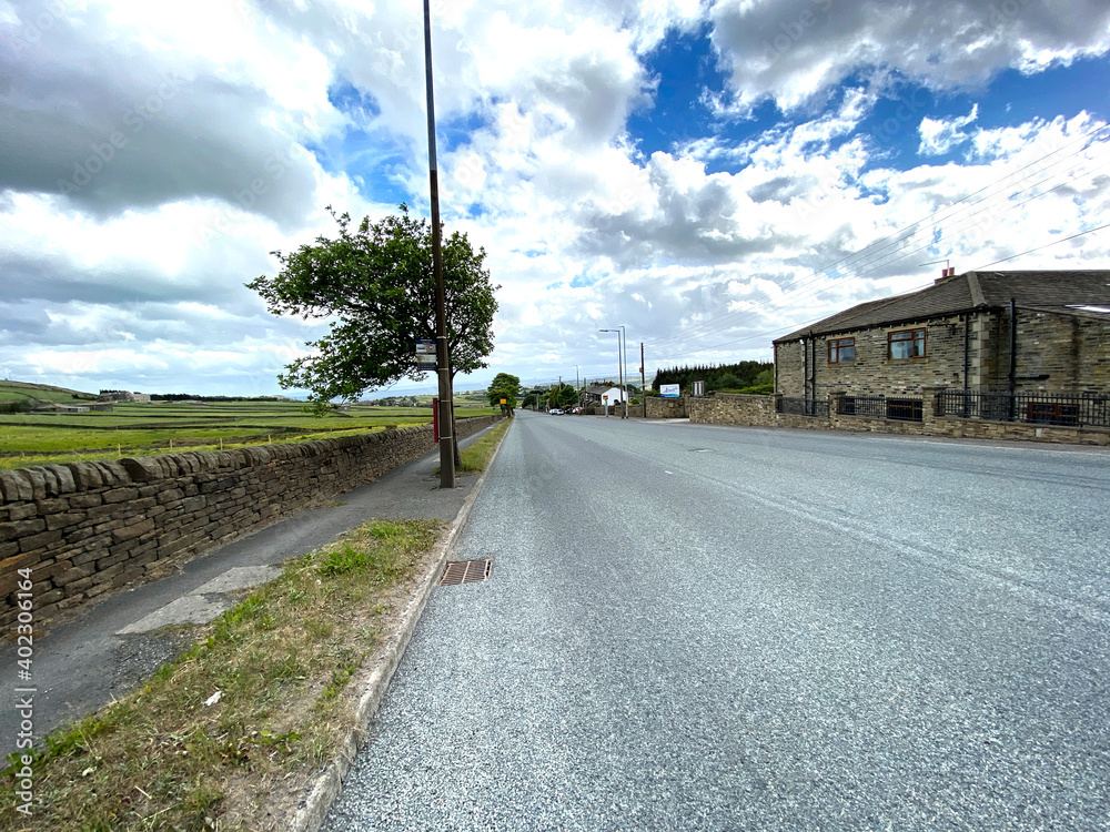 View along the, Causeway Foot road, with fields and houses near, Halifax, Yorkshire, UK