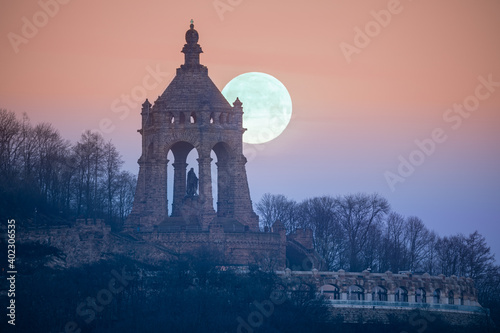 The moon setting behind the Kaiser Wilhelm Monument in Porta Westfalica