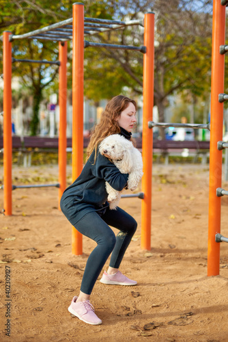 girl doing exercises with a dog in her hands