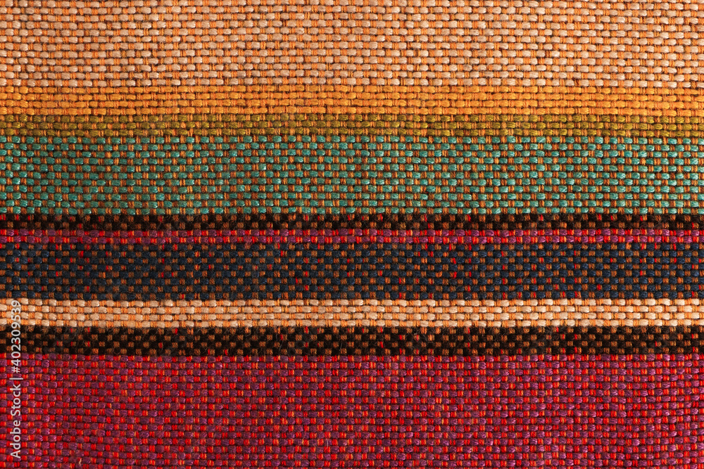 Sample of woolen fabric with red-green-yellow stripes and textured weave of threads. Blank background and close-up. Sample of woolen fabric with red-green-yellow stripes and textured weave of threads. Blank background and close-up.