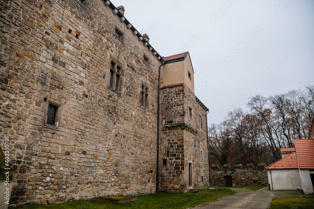 Fortified medieval stronghold, Moated gothic castle at romantic style, National cultural landmark in winter day, Budyne nad Ohri, Northwest Bohemia, Czech Republic