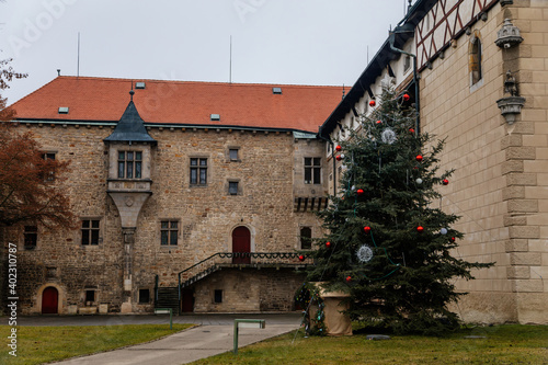 Fortified medieval stronghold, Moated gothic castle at romantic style, National cultural landmark with Christmas tree in winter day, Budyne nad Ohri, Bohemia, Czech Republic photo