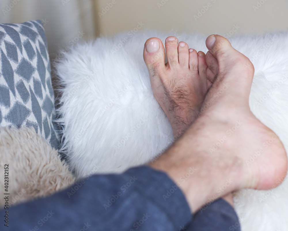 Man's feet on a fluffy white cushion Man's feet on a fluffy white cushion