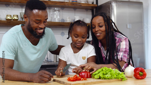 Happy african family in kitchen having fun and cooking together