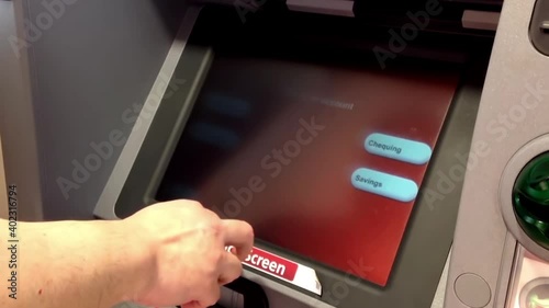 Man depositing cheque at ATM machine inside Cibc bank photo