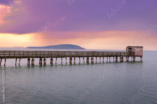 Romantic view of a Wooden Pier  with birdwatching hut in Trasimeno lake in the purple light of the sunset  Magione   Umbria  Italy.