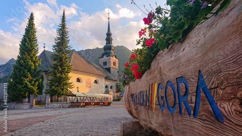 Vászonkép CLOSE UP: Scenic shot of a wooden planter and the church in Kranjska Gora