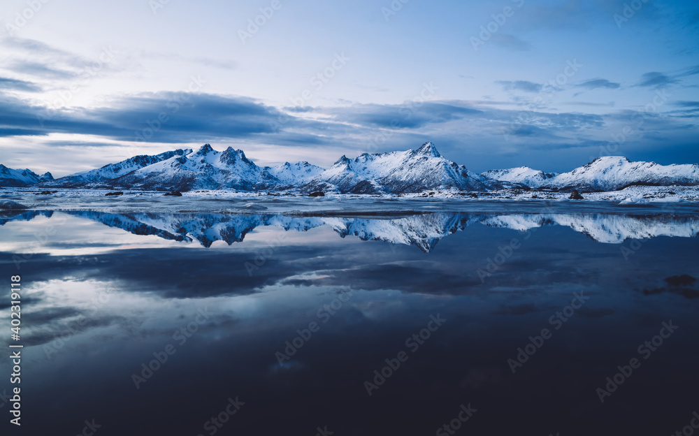 Calm crystal bay surrounded with snowy mountains