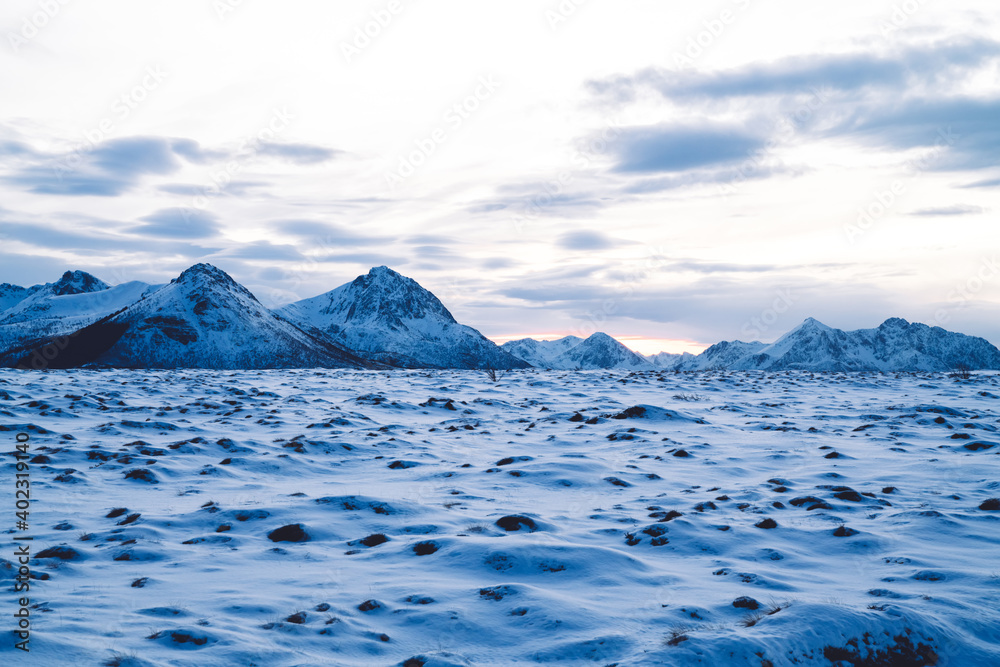 Rough snowy mountains surrounded with frozen sea