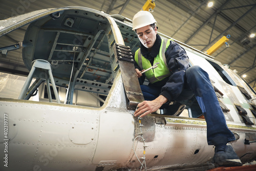 Portrait of a Caucasian man , factory engineer in work clothes controlling the work process at the helicopter manufacturer.  photo