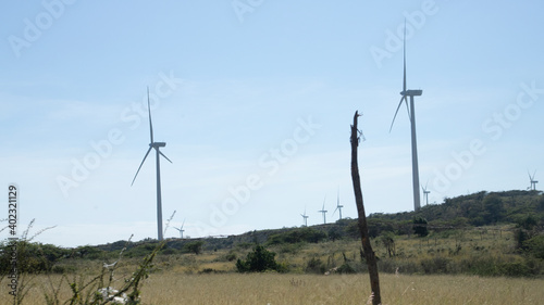 WIND GENERATORS IN A CLEAN ENERGY PARK ON TOP OF A HILL WITH THE SKY IN THE BACKGROUND