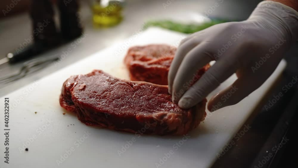 Cooking beef steak at home, Beef fillet on the Cut Board, Juicy steak with grilling stripes, Chef salt grilled meat at stone cutting board