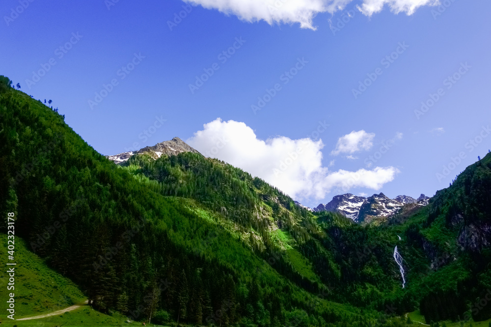 blue sky with white clouds with hiking trails in the summer