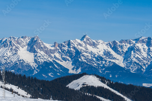 View of the snow-capped mountains in the Schmitten ski area in Zell am See. In the background is a beautiful sky with clouds.