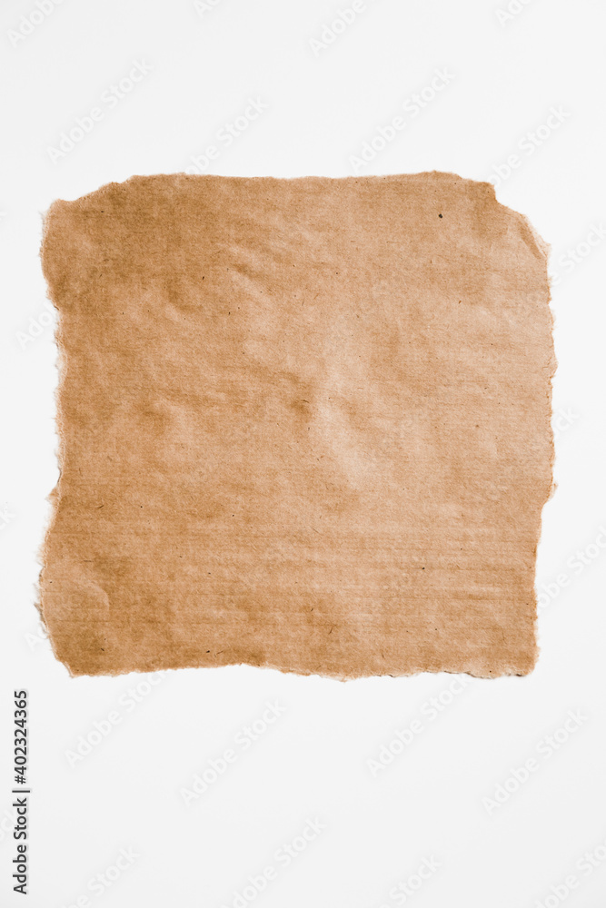 Torn square brown piece of paper with ripped edges isolated on white.