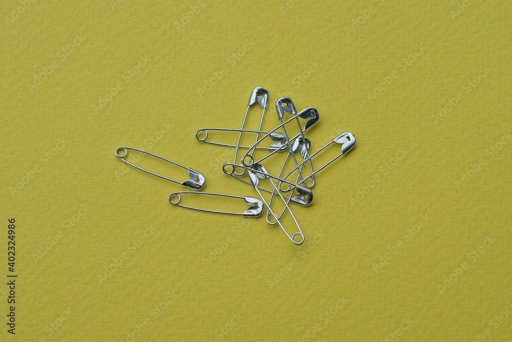 Fototapeta premium a bunch of many gray metal pins lie on a yellow table