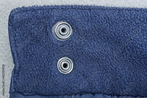 two gray metal rivets on a blue cloth
