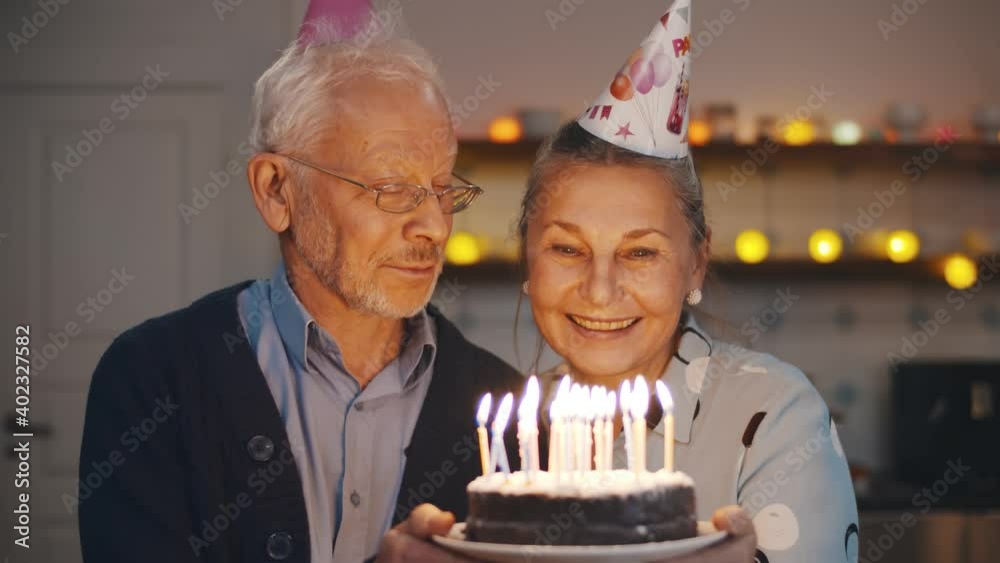 Happy senior couple celebrating anniversary or wife birthday at home