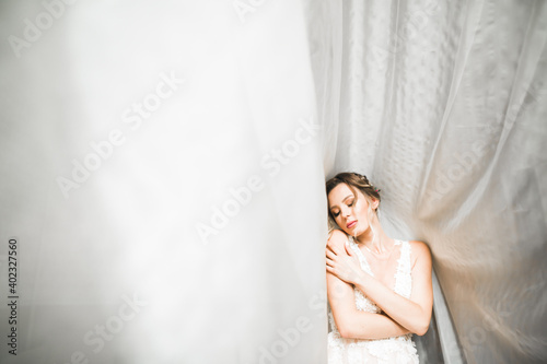 Portrait of beautiful bride with fashion veil at wedding morning